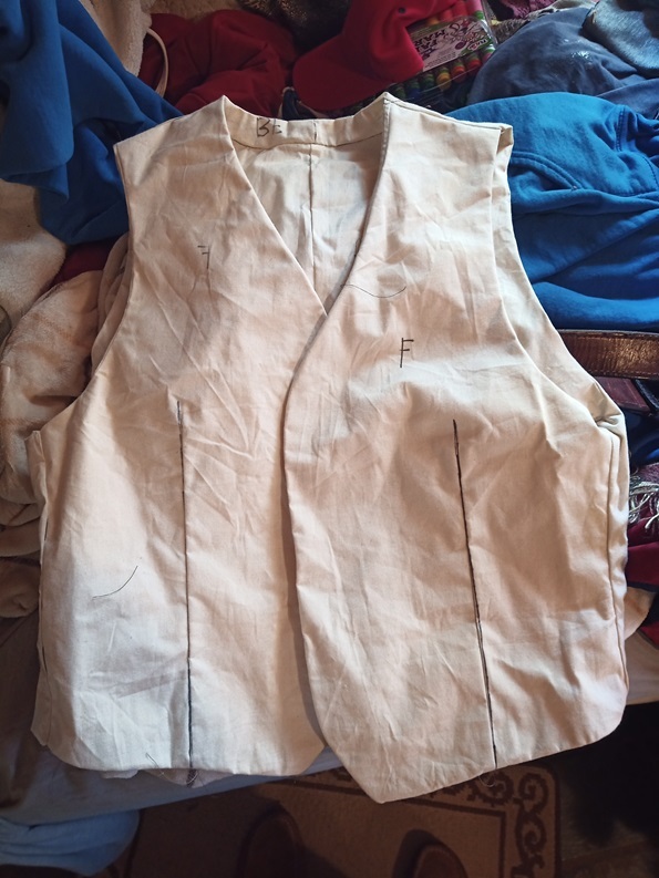 Mockup of a waistcoat made of tan muslin material with markings all over it.