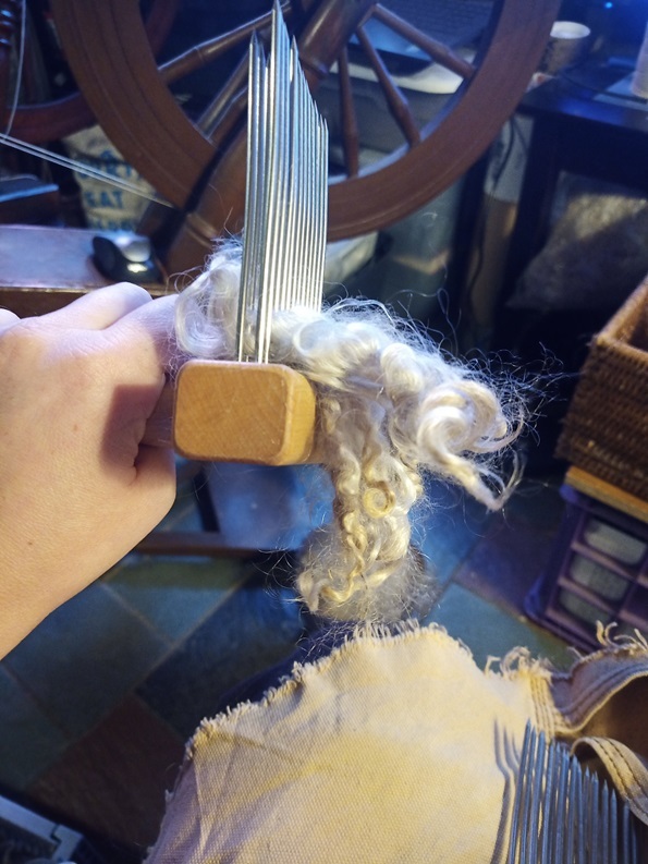 A wool comb loaded with a small amount of mohair locks