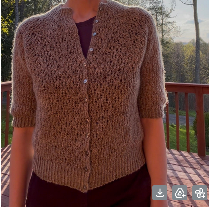 A picture neckdown of a woman wearing a beautiful grey knitted cardigan.
