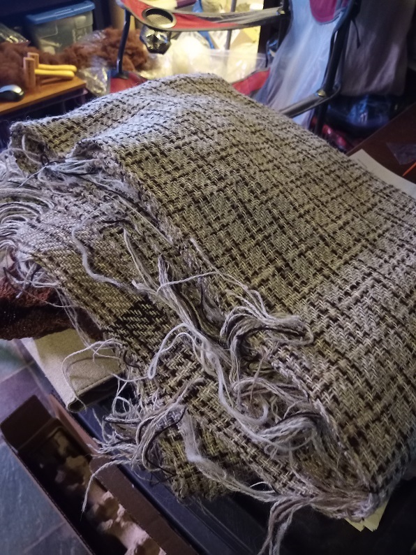 A pile of plaid cloth takes up most of the photo.