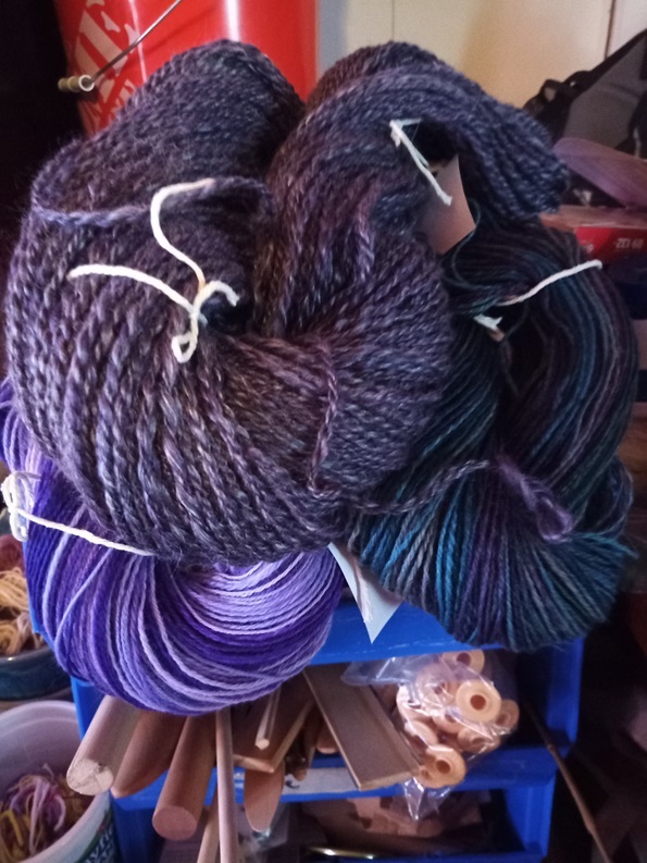 A couple of different colored skeins laying on top of each other.