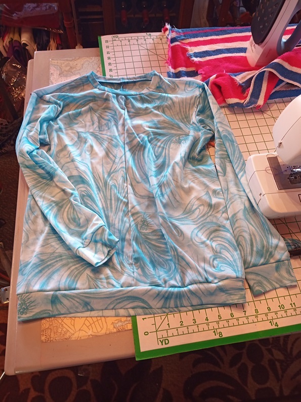 A pale blue patterned long sleeve shirt is sitting a little scrunched up.
